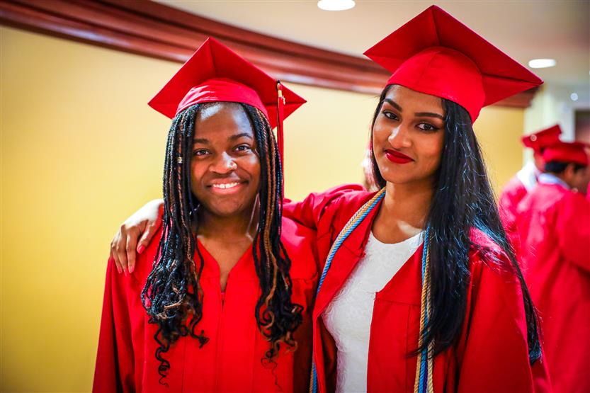 Students in red robes graduate